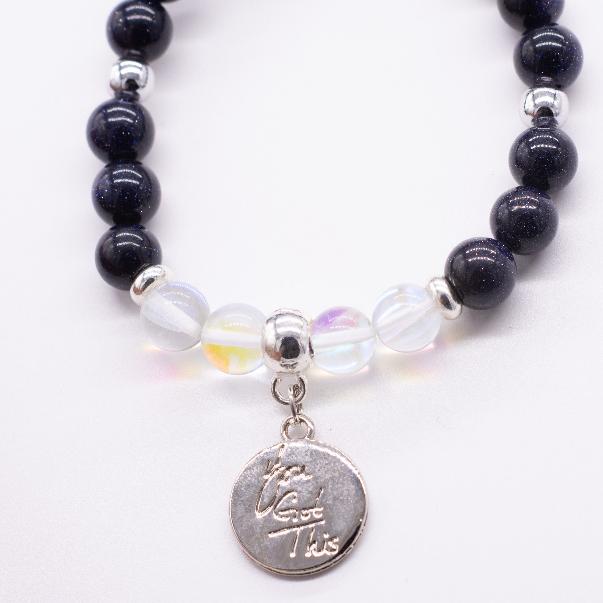 a beaded bracelet with a silver charm